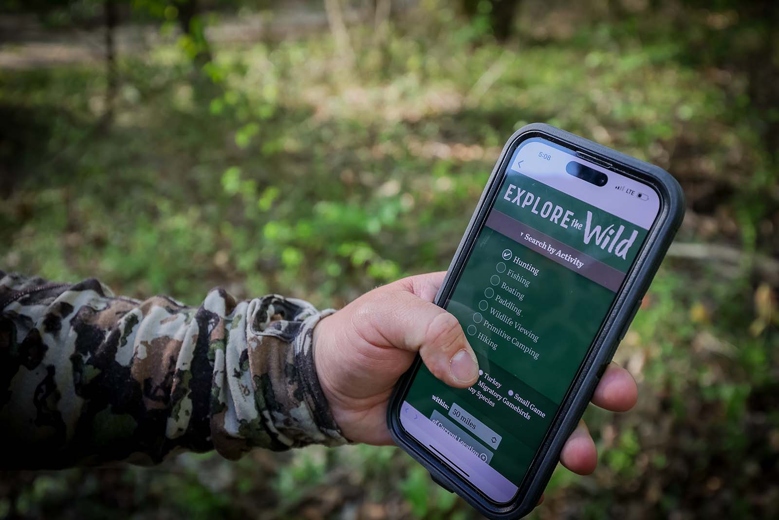 手握著智能手機，顯示了探索野生動物