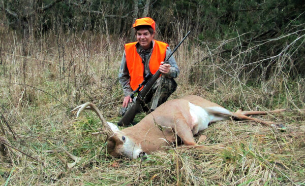 一個獵人與死的牛合拍照的圖像