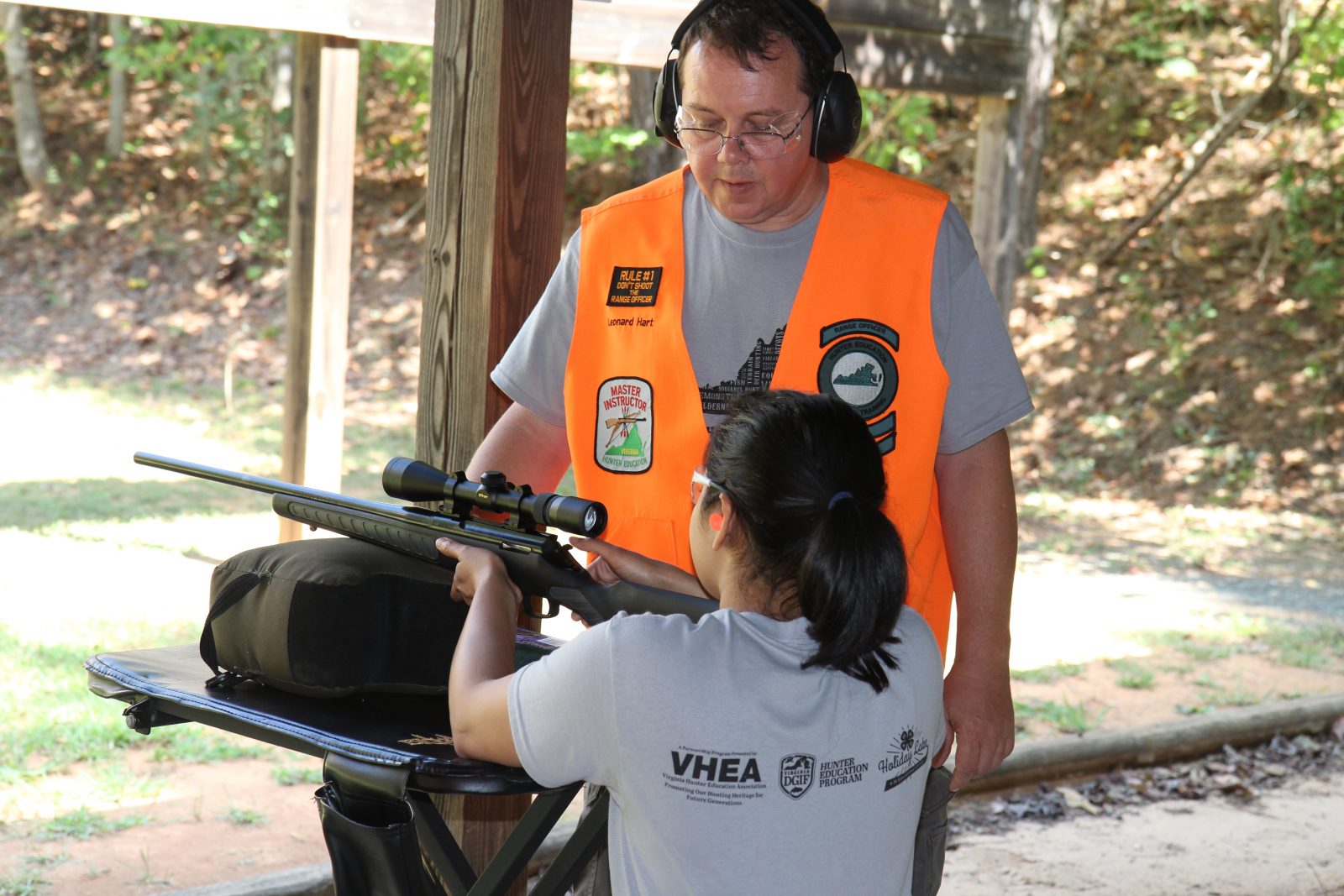一個女孩學習如何射槍的照片
