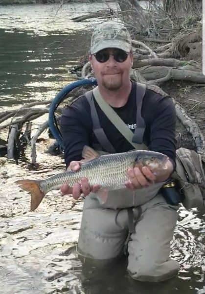 傑瑞霍爾(Jerry Hall)在濕地裡拿著他州紀錄大小的落魚的圖像