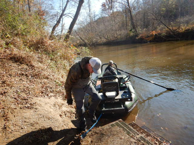 綠色電釣魚艇與兩名員工從陸地上拆卸