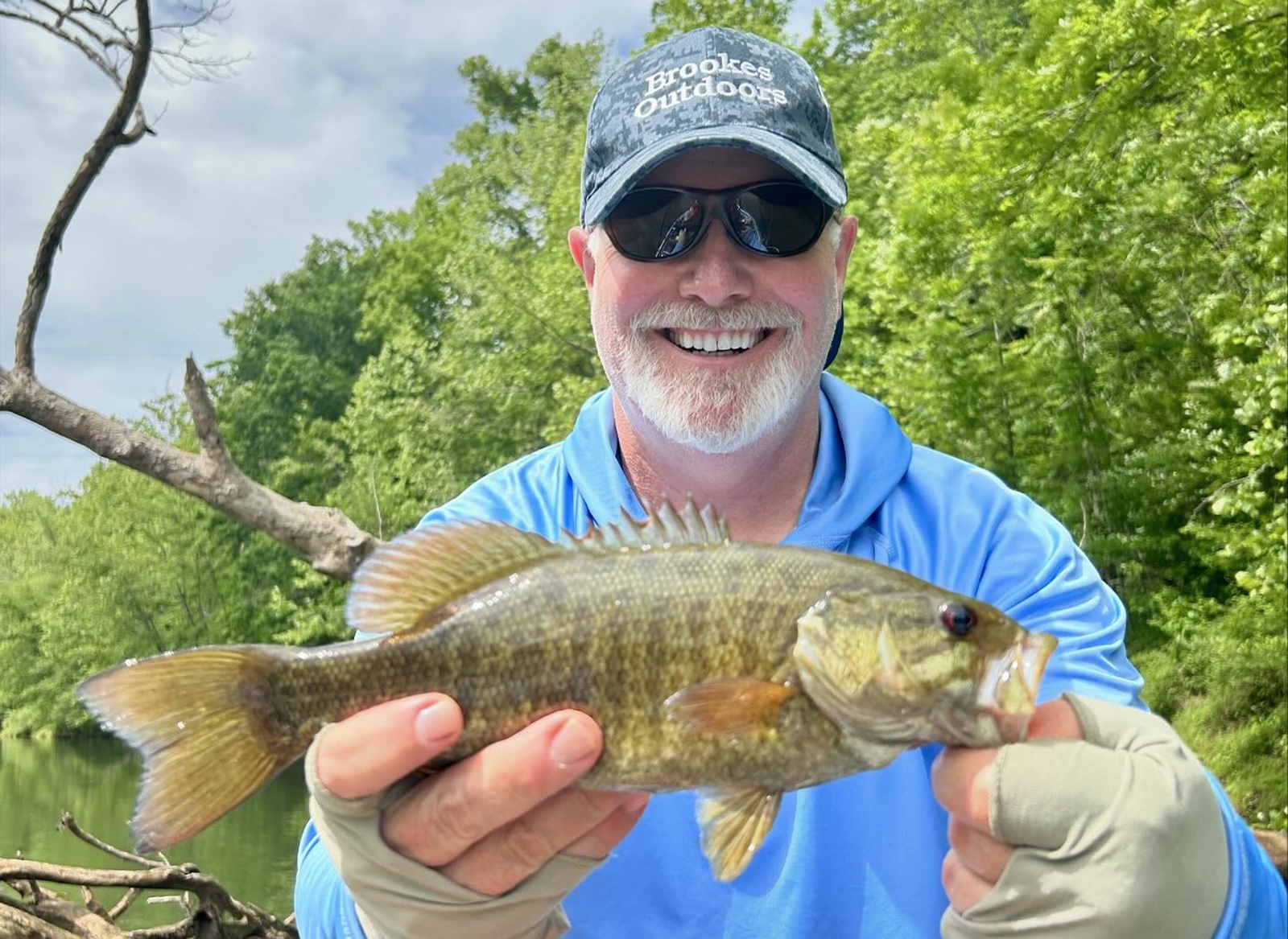 一個男人拿著一隻小嘴巴魚作照片。