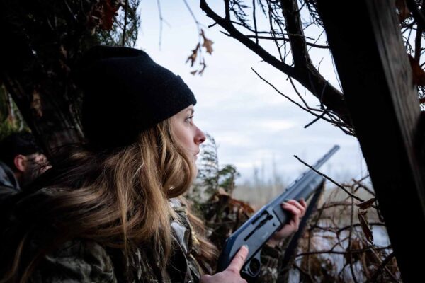 一位在水邊狩獵盲人身穿著迷彩的女人