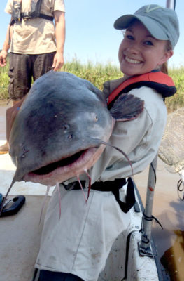 一個女孩抱著一隻大的藍色魚